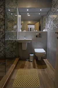 普洛耶什蒂皇冠酒店的一间带水槽、卫生间和镜子的浴室