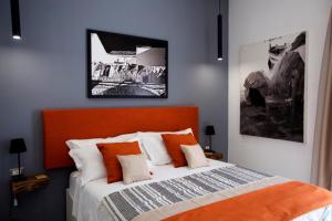 那不勒斯Scugnizzo Apartment Luxury Home的一间卧室配有一张带橙色床头板的床