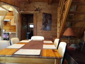 奥克宁卡Chata u Sylwii的一间带木桌和白色椅子的用餐室