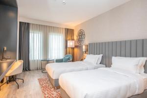安卡拉Crowne Plaza Ankara, an IHG Hotel的酒店客房配有两张床和一张书桌