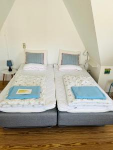 马斯塔尔Færgestræde 45的两张睡床彼此相邻,位于一个房间里