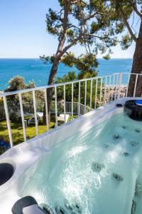 维耶特里Decori Suites Amalfi Coast的背景为海洋的热水浴池
