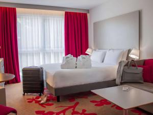 图尔图尔北美居酒店的酒店客房设有一张大床和红色窗帘