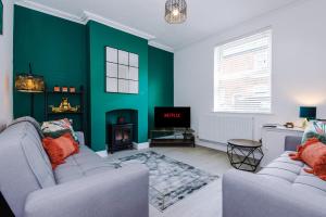 切斯特Faulkner House的客厅设有两张沙发和一堵绿色的墙