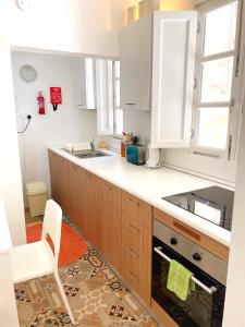 森格莱阿MoCo, modern comfort in historic city of Senglea的厨房配有木制橱柜和白色台面