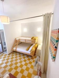 森格莱阿MoCo, modern comfort in historic city of Senglea的小房间设有双层床和 ⁇ 板地板