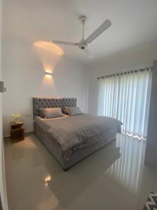 Athurugiriya3 Bedroom Apartment, Ariyana Resort的一间卧室配有一张床和吊扇