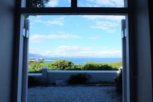 赫曼努斯11 WESTCLIFF RENTALS的从房子的窗户欣赏到海景