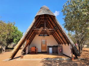 帕拉博鲁瓦Masorini Bush Lodge的茅草屋顶的小房子