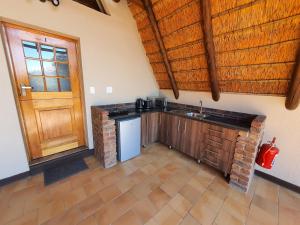 帕拉博鲁瓦Masorini Bush Lodge的一个带水槽和木门的厨房