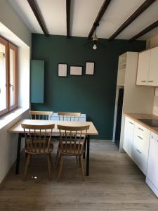 Arrens-MarsousMaisonette 'La Toue' in Pyrenees National Park的厨房配有桌椅和绿色的墙壁