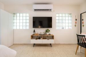 Ramat Yishayירוק באלה - דירת נופש ברמת ישי的一间客厅,在白色的墙上配有电视