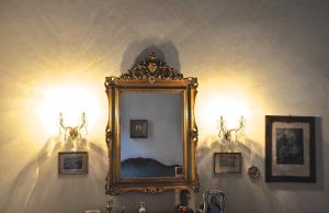 帕多瓦帕拉佐阿尔提那特 - 诺特迪皮亚诺公寓的墙上的镜子,有两盏灯和一个水槽