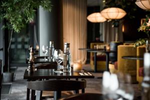 哥德堡阿尔肯及艺术花园Spa酒店的餐厅设有桌子、酒杯和蜡烛