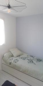 阿尔宗Appt entier Résidence de la Plage Vue Mer Port Navalo的白色卧室内的一张床位,卧室设有天花板