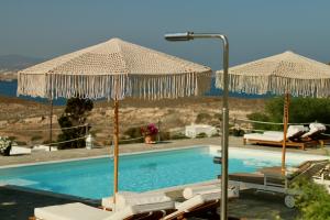 帕罗奇亚蓝海湾和里斯酒店的一个带两把遮阳伞和一些椅子的游泳池