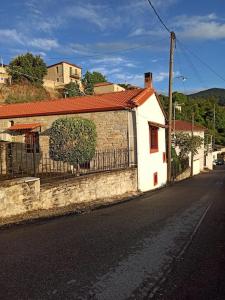 VamvakoúMagnolia Traditional Stone House in Vamvakou的街道旁的白色建筑,有栅栏