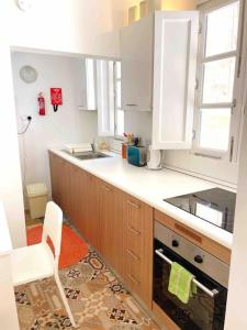 森格莱阿MoCo, modern comfort in historic city of Senglea的厨房配有白色橱柜和炉灶烤箱。