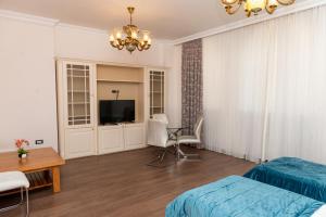 巴库Utopia Hotel Baku的一间卧室配有一张床、一台电视和一张桌子