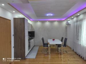 OdžakHome of nature - kuća prirode的厨房以及带桌子和紫色灯的用餐室