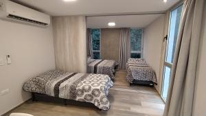 OncativoApart Hotel La Campiña的一间卧室设有两张床和窗户。