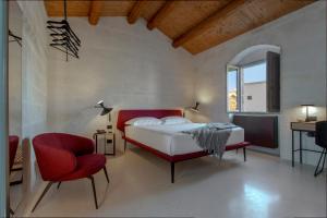 马泰拉PIANELLE RESORT的一间卧室配有一张床和一张红色椅子