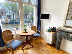 阿姆斯特丹Canal Hideaway的客房设有桌椅和窗户。