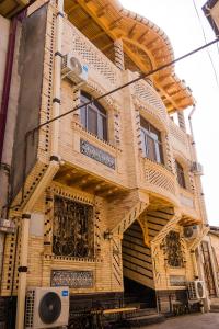 撒马尔罕Durdona Guest House的街道上带阳台的木质建筑