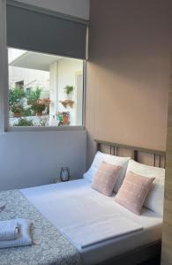 卡瓦拉Sofis Garden的一间卧室配有一张带两个粉红色枕头的床