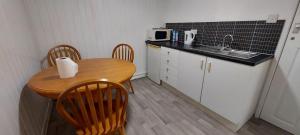 罗瑟勒姆Lovely 3-Bed Apartment in Parkgate Rotherham的小厨房配有桌椅和水槽