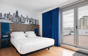 拉科鲁尼亚Eurostars Blue Coruña的卧室设有白色的床和大窗户