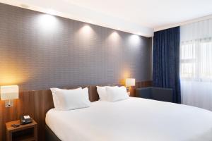 维特罗勒马赛普罗旺斯区机场基里亚德酒店的酒店客房配有一张带白色枕头的大床