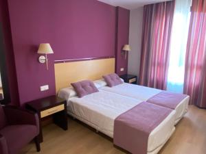 阿兰约兹Hotel Equo Aranjuez的一间卧室设有一张紫色墙壁的大床