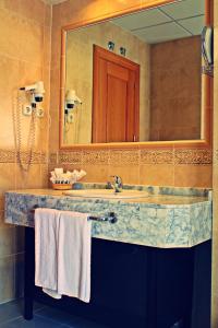 阿兰约兹Hotel Equo Aranjuez的浴室配有盥洗盆、镜子和毛巾