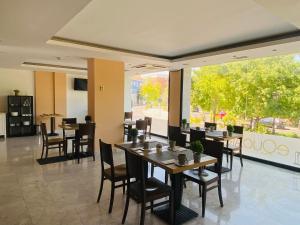 阿兰约兹Hotel Equo Aranjuez的餐厅设有桌椅和大窗户。