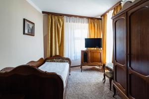 托伦波洛尼亚酒店的一间卧室配有一张床、梳妆台和电视。