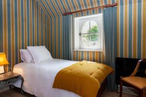 博韦La maison de Michel的一间卧室配有一张带黄色毯子和窗户的床