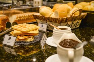 巴乌鲁巴乌鲁舒适酒店的餐桌上摆放着面包、华夫饼和一盘食物