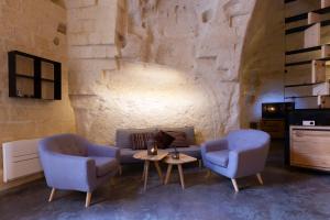 马泰拉Grotta Barisano的客厅配有两把椅子、一张沙发和一张桌子