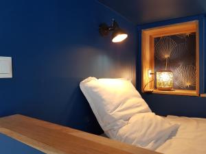 布雷斯特Brest : Beau T1 en centre ville的一间卧室设有蓝色的墙壁和一张带窗户的床