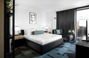 拉斯维加斯Downtown Grand Hotel & Casino的配有一张床和一把椅子的酒店客房