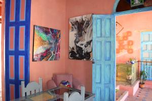 圣克里斯托瓦尔-德拉斯卡萨斯Gran Barrio的一间墙上挂有画作的用餐室和一张玻璃桌