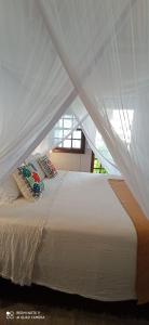 科鲁里皮Vila Bello Pontal的卧室配有白色的床和枕头。