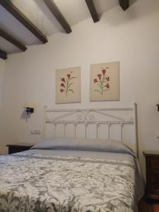 卢克Casa Rural Alamillo的卧室配有一张墙上有两张照片的床。