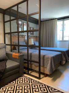 巴拉曼萨Studio aconchegante em Barra Mansa的一间带两张双层床和一张沙发的卧室