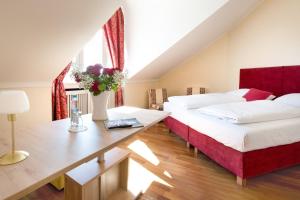 慕尼黑Hotel Aurbacher Hof GmbH的一间卧室配有两张床和一张鲜花桌