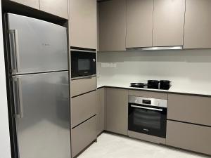 吉隆坡Eaton Suites KLCC的厨房配有不锈钢冰箱和微波炉。