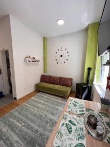 别拉什尼察Green Oasis的客厅配有沙发和墙上的时钟