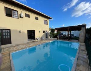 里约热内卢Buganville House Cabo Frio的房屋前的游泳池