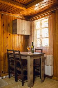 库塔伊西Eco Cottage的厨房配有一张桌子和一杯葡萄酒